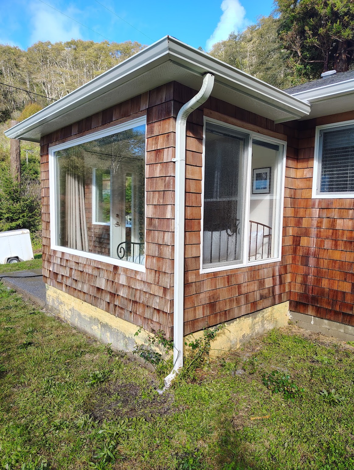 Cedar shake siding and white gutters after a Diamond Touch wash, free of dark staining